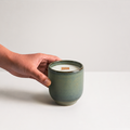 Denim Candle with hand reaching toward vessel