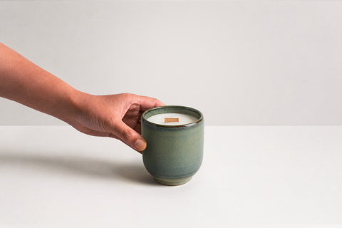 Denim Candle with hand reaching toward vessel